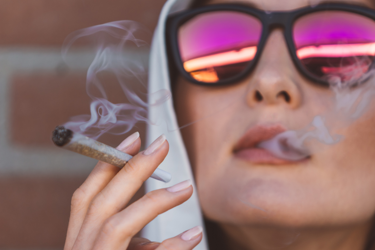 Young woman smoking a preroll to represent a blog about dispensary with delivery near me in pahrump