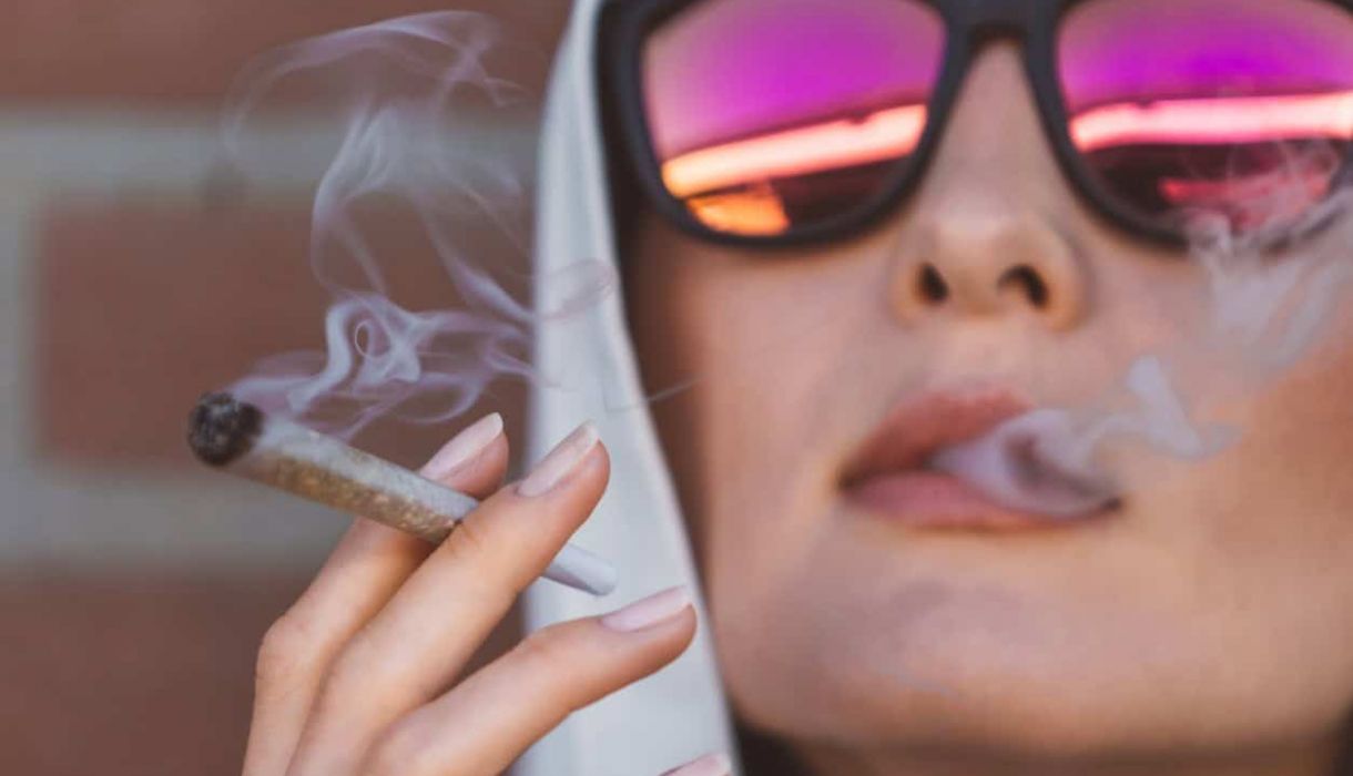 Young woman smoking a preroll to represent a blog about dispensary with delivery near me in pahrump