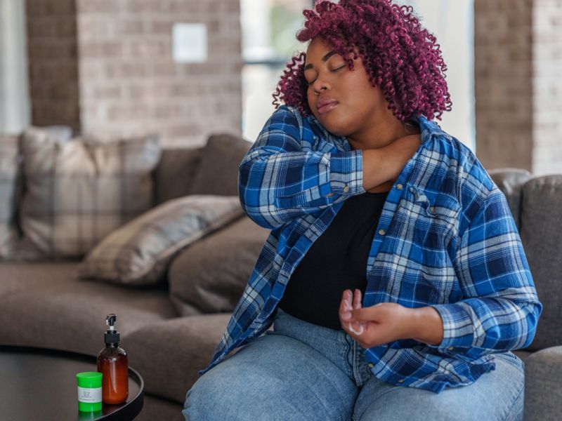 A person applies a cannabis topical to their shoulder at home.